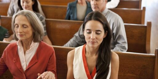 a25 Two women holding hands in church pews